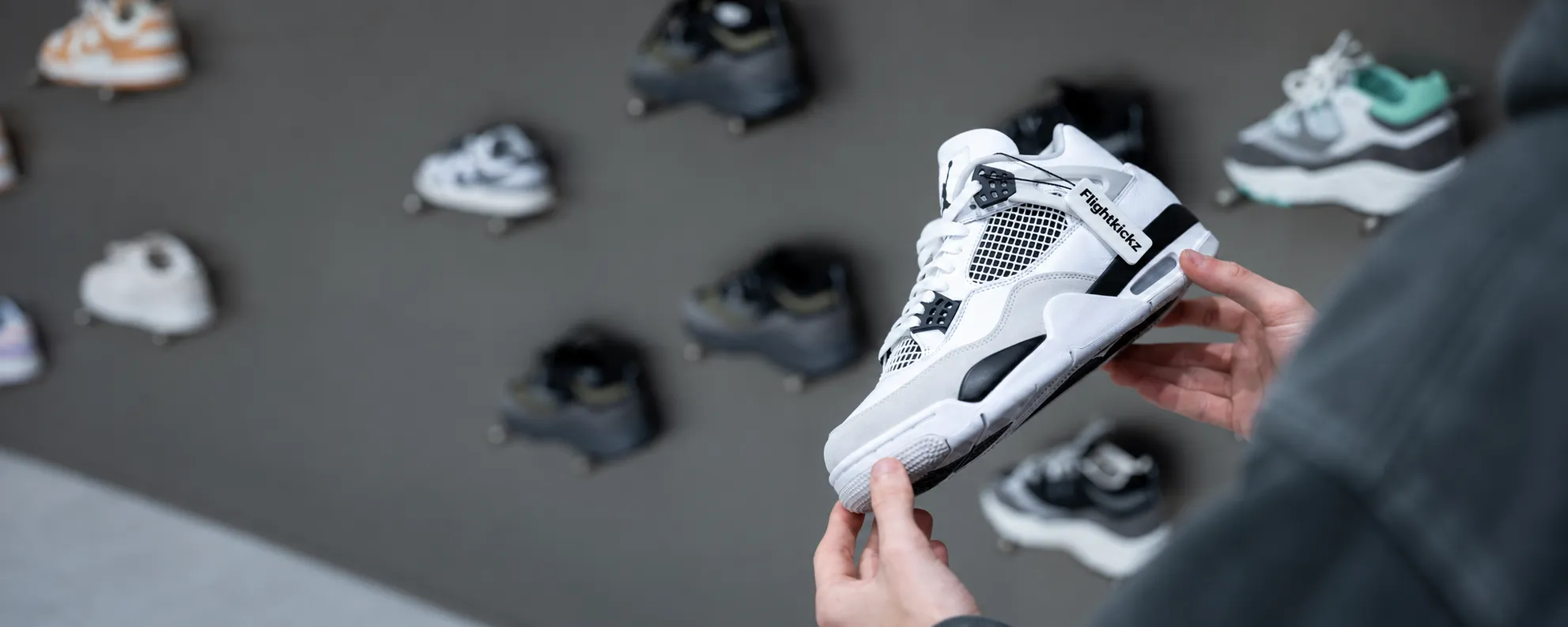 A black sneaker with a Flightkickz tag being inspected before shipping