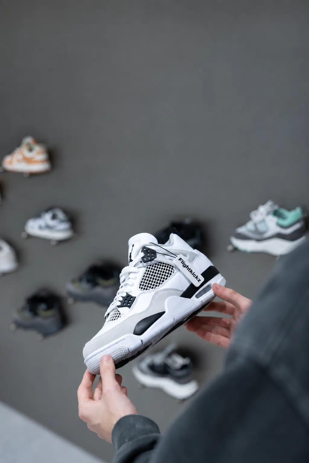 A black sneaker with a Flightkickz tag being inspected before shipping